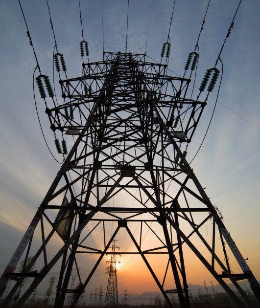 High voltage electricity pylon over sunset.